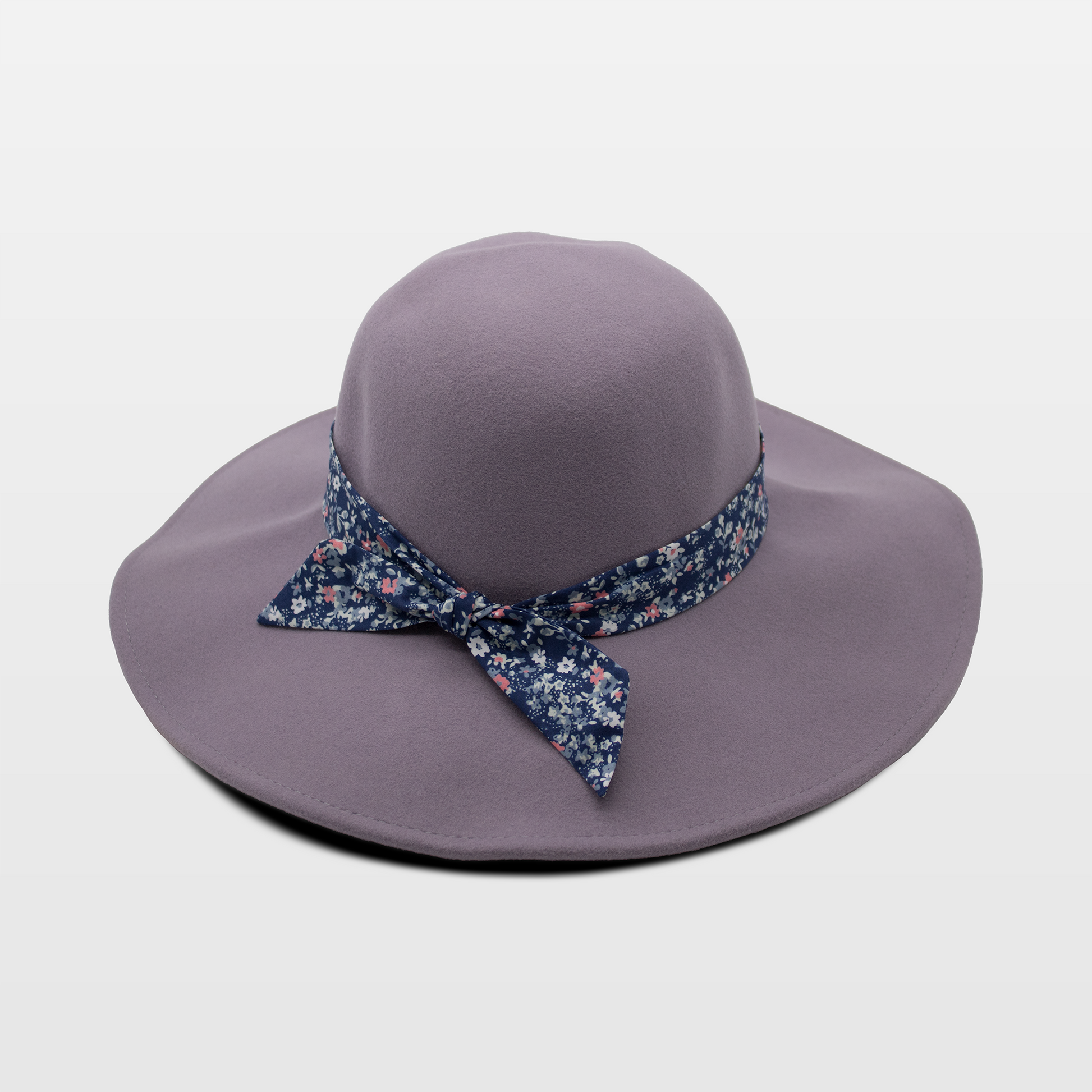A stylish lavender hat with a wide brim, adorned with a blue floral-patterned band tied in a bow