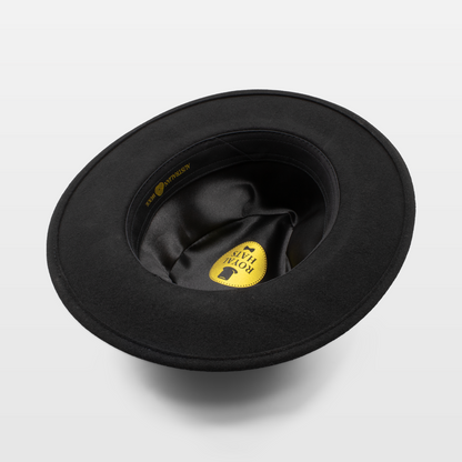 View of the interior of a black felt hat with a satin lining and a gold Royal Hats label