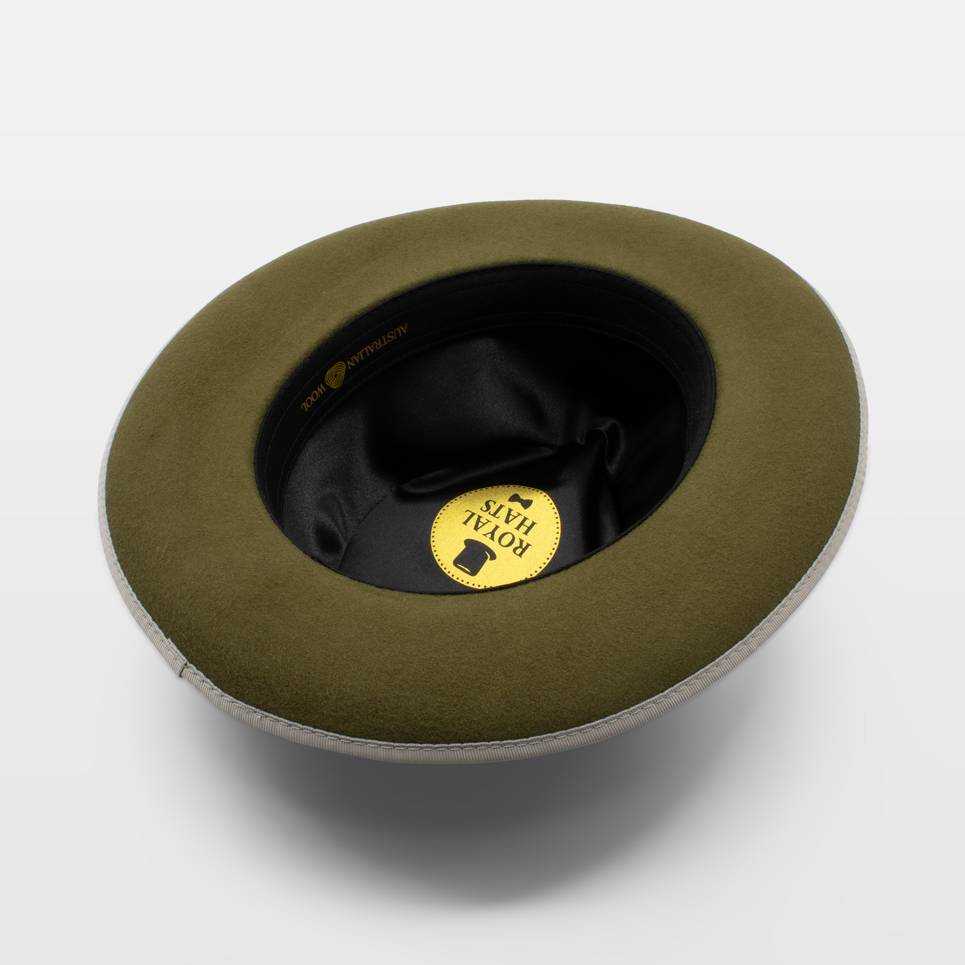 Interior view of an olive green felt hat with a white brim and satin interior