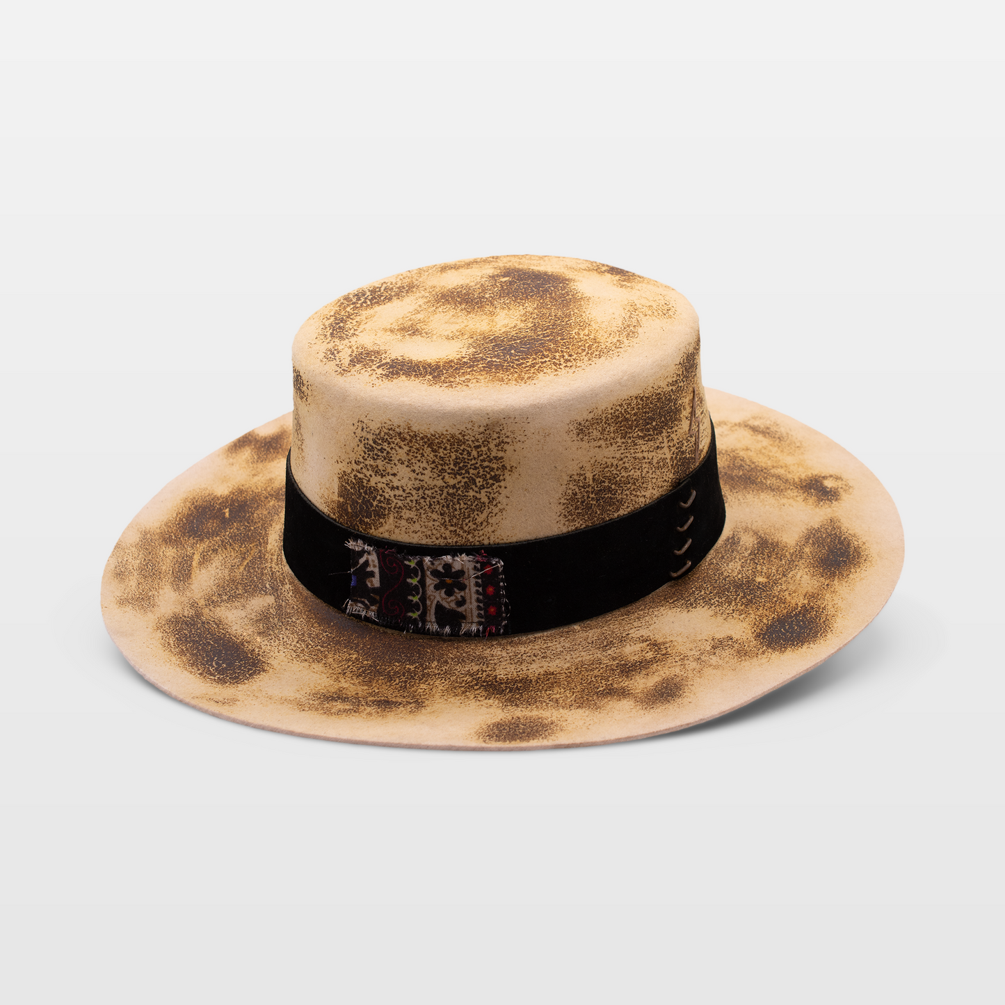 Beige wide-brimmed hat with a weathered look and a black band with embroidered details