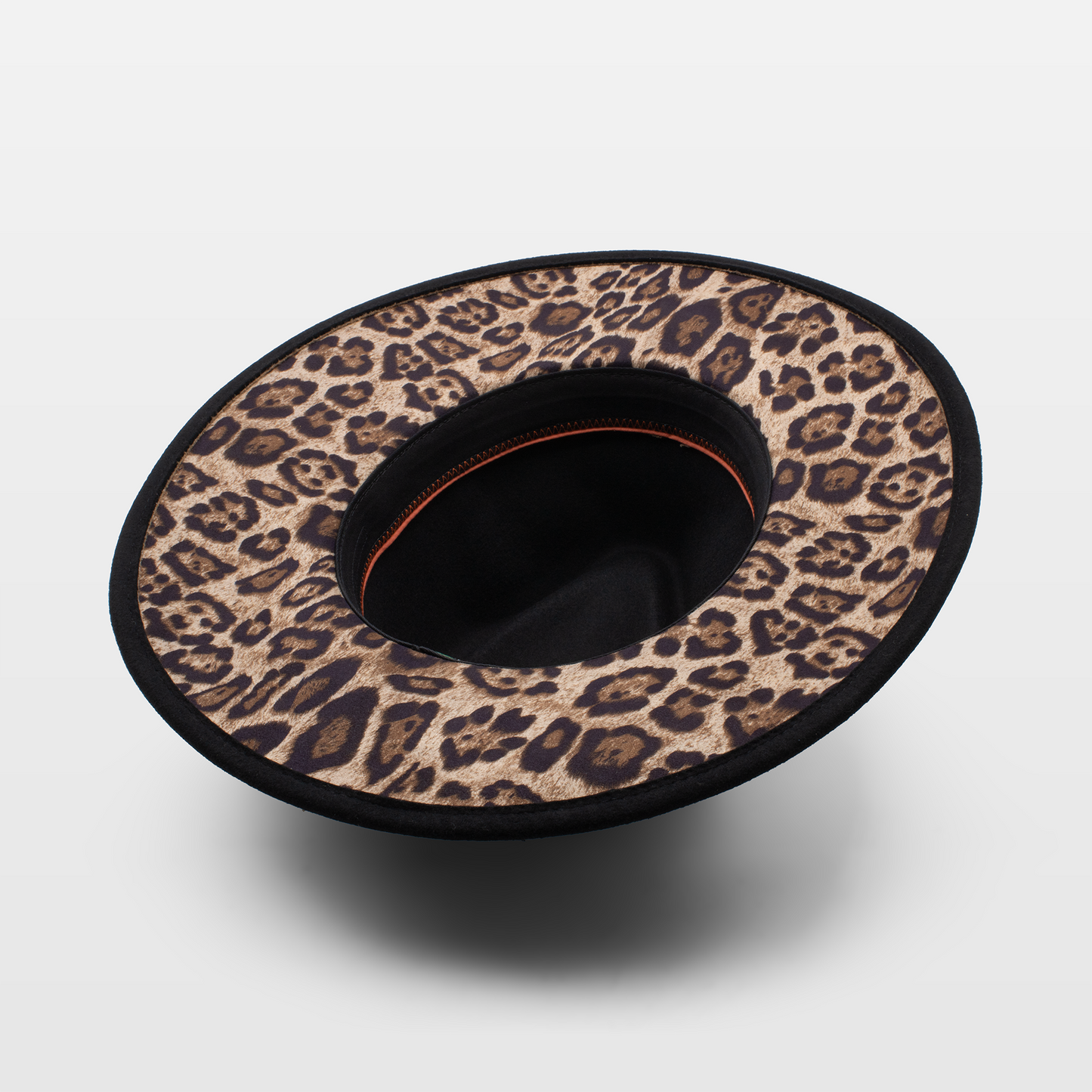 Wide-brimmed hat with a leopard print lining, shown upside down to display the interior