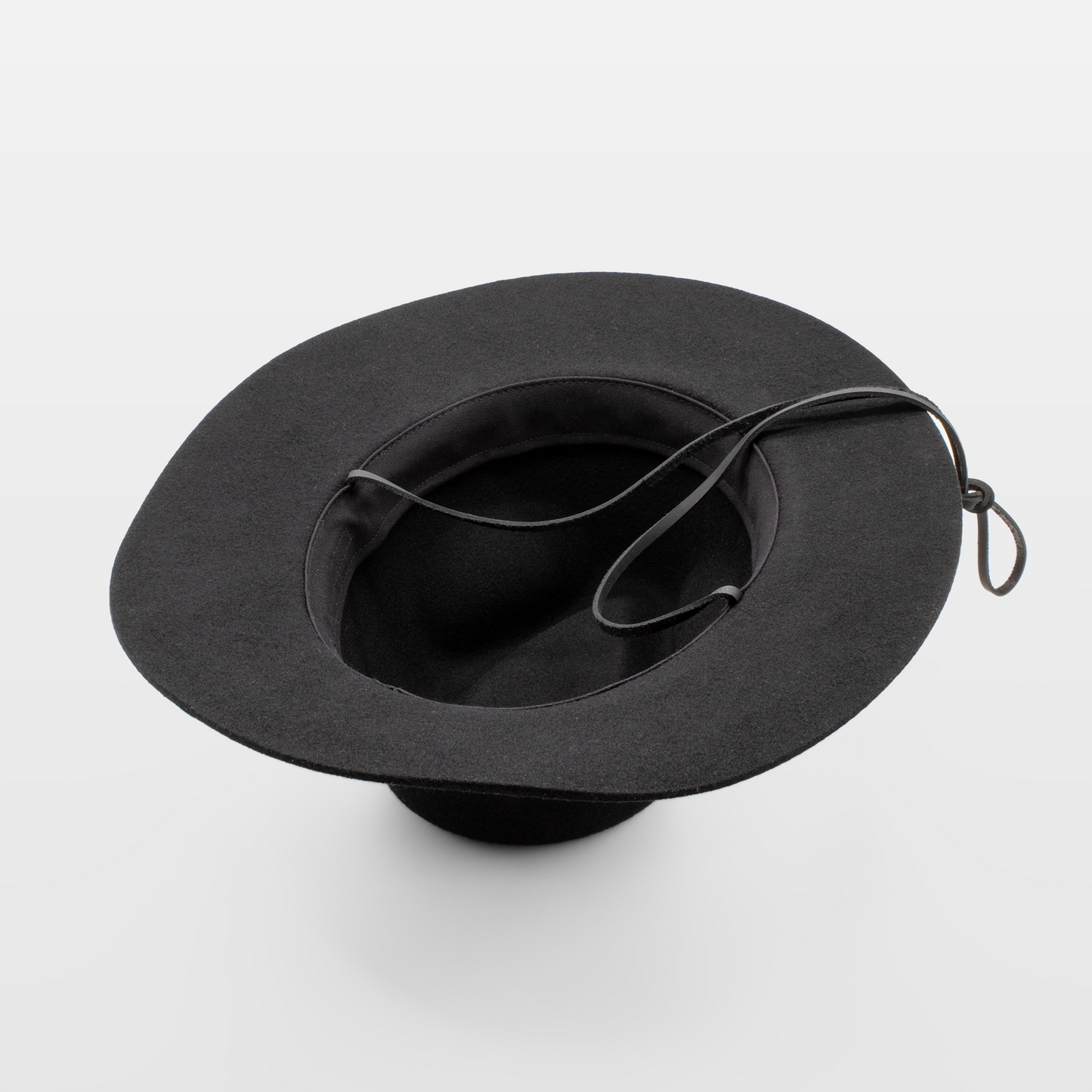 Black wide-brimmed cowboy hat, shown upside down with a black chin strap