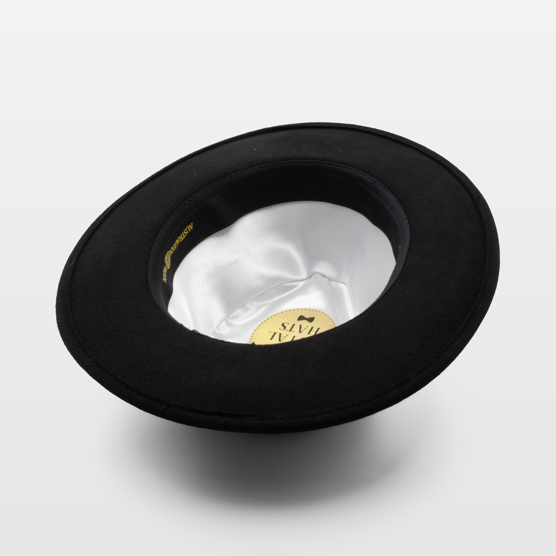 Black hat shown upside down to display the white satin interior