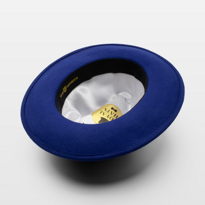 Blue wide-brimmed hat shown upside down to display the white satin interior