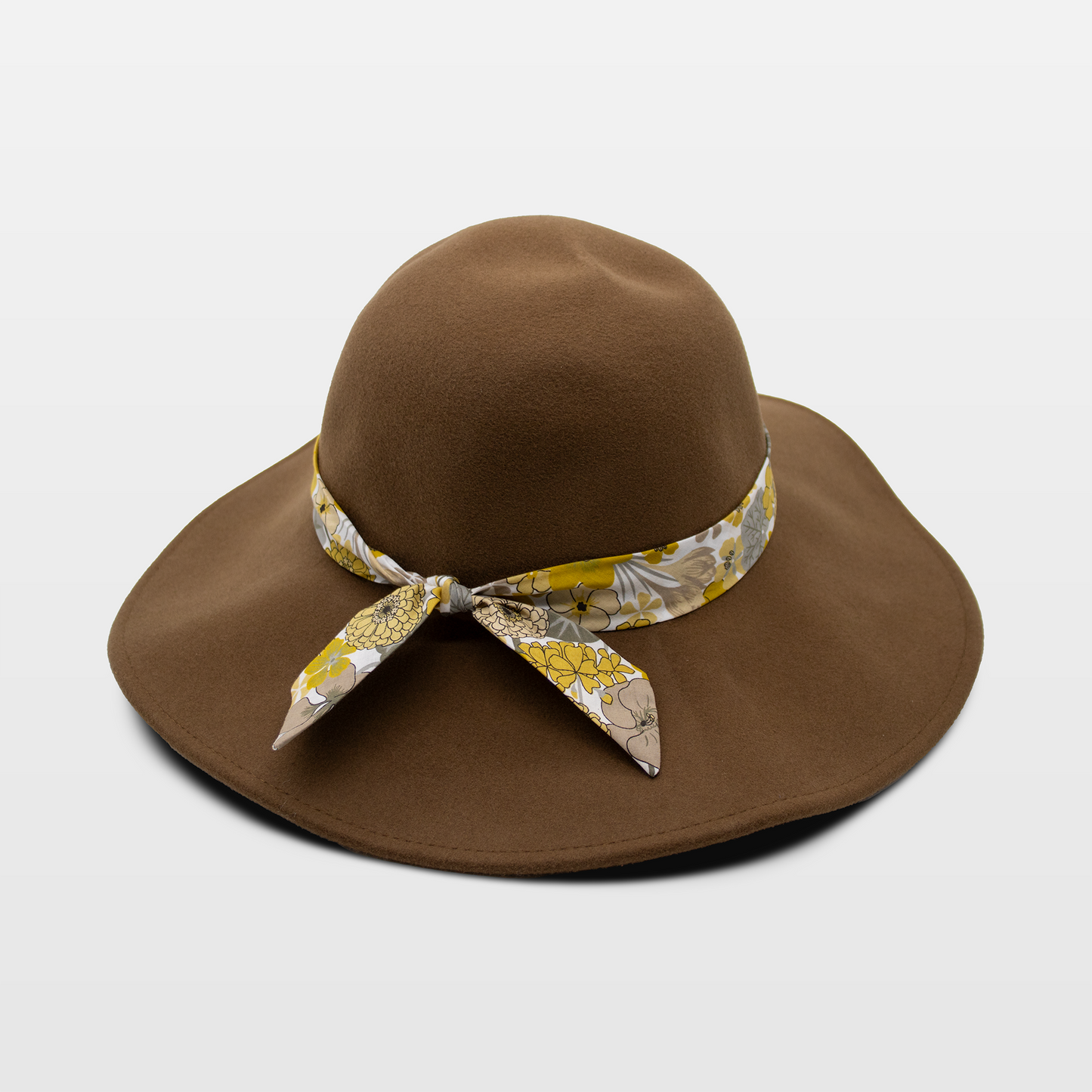 A stylish brown hat with a wide brim, adorned with a floral-patterned band tied in a bow