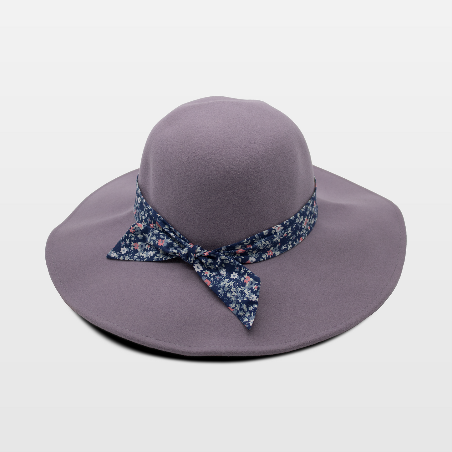 A stylish lavender hat with a wide brim, adorned with a blue floral-patterned band tied in a bow