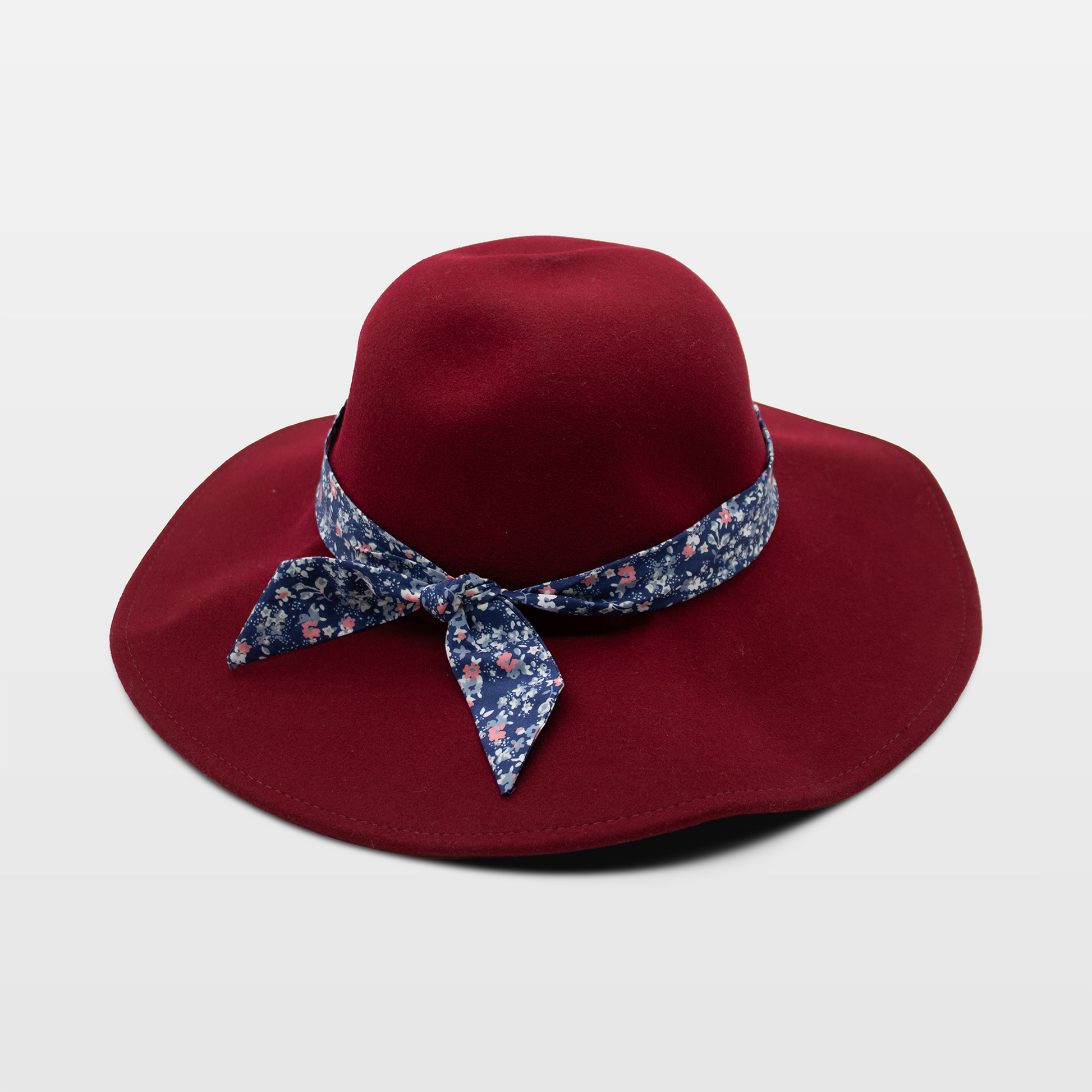 A burgundy hat with a wide brim, adorned with a blue floral-patterned band tied in a bow